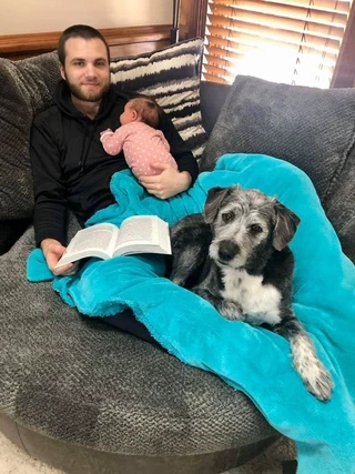 My daughter Piper and I weeks after she was born reading a book with our dog Percy.